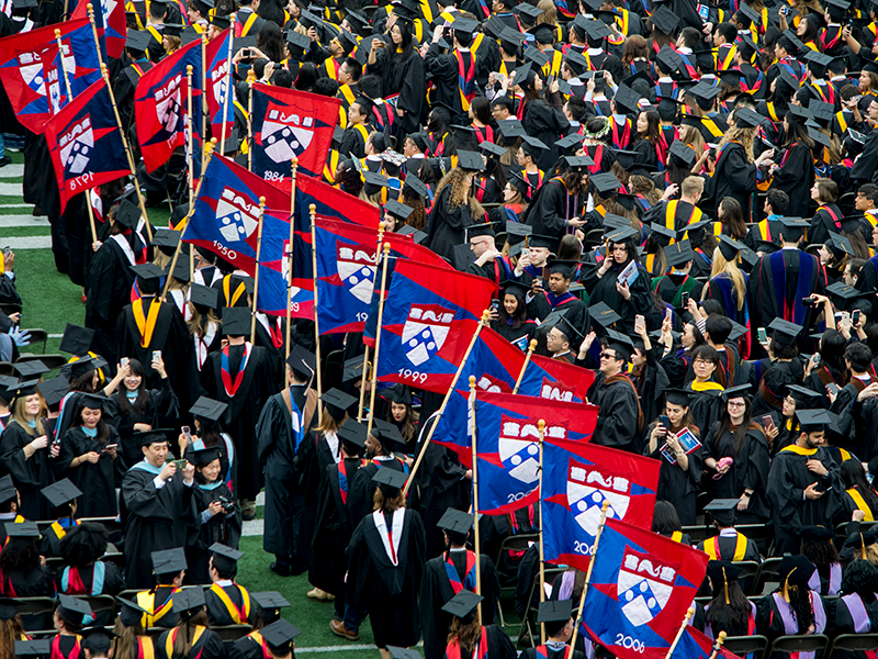 graduates in an alumni flag procession