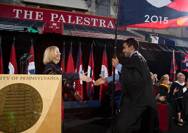 Amy Gutmann shaking hand of 2015 flag bearer