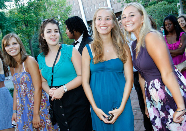young women in dresses gathered outside
